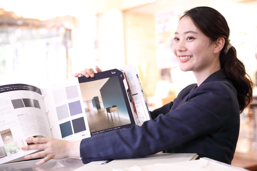 パンフレットを見せる女性